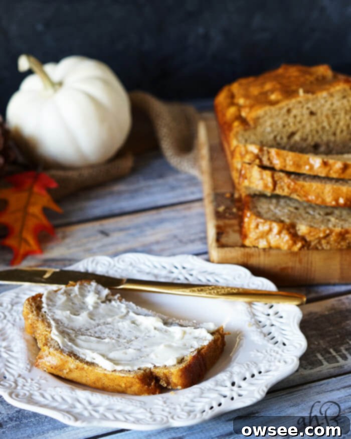 Spiced Pumpkin Beer Bread 4 Close-up of pumpkin beer bread with a golden-brown crust, drizzled with honey butter.