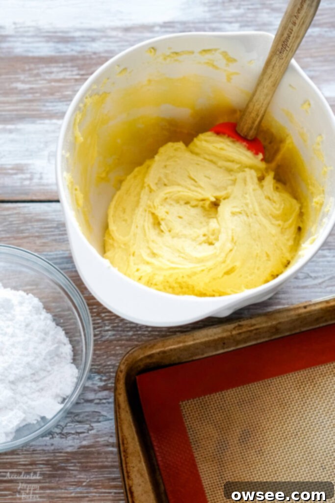 Zesty Lemon Crinkle Cookies 5 Step one is to combine the lemon cake mix with the butter and eggs.