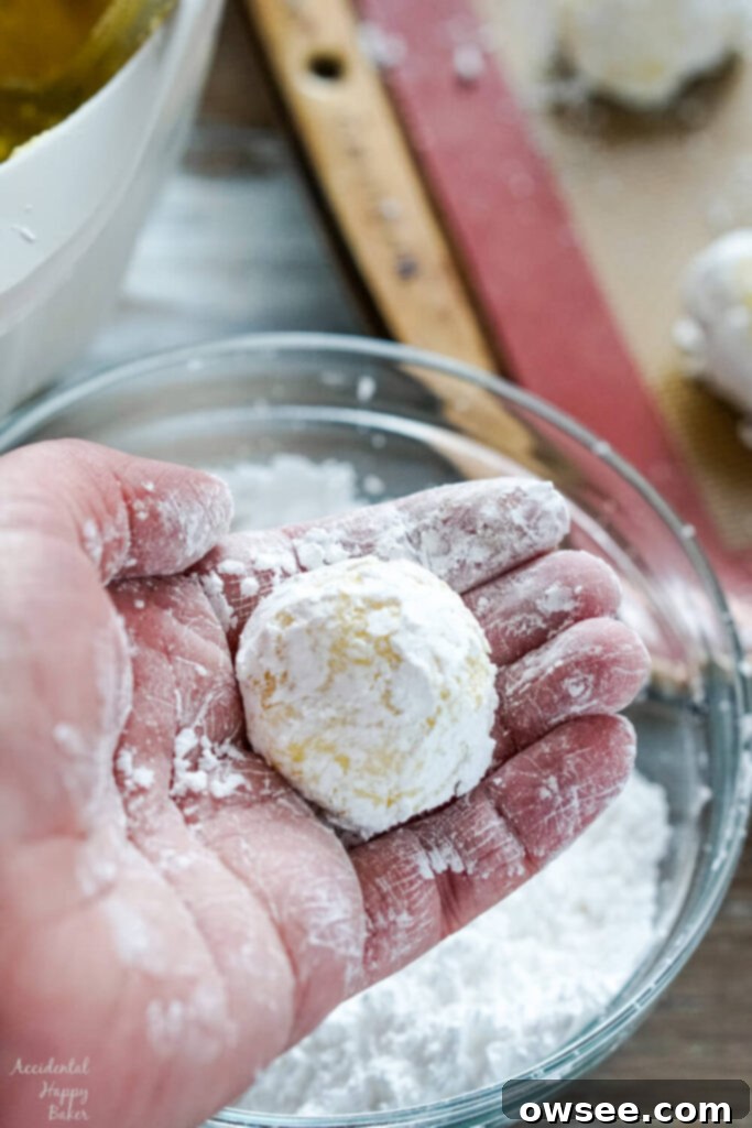 Zesty Lemon Crinkle Cookies 6 Step two, rolling the cookie dough into balls and then rolling the balls in powdered sugar.