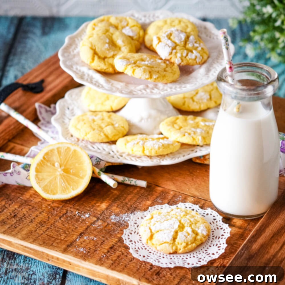 Zesty Lemon Crinkle Cookies 8 Delicious lemon crinkle cookies on a wooden tray with a glass of milk and sliced lemon.