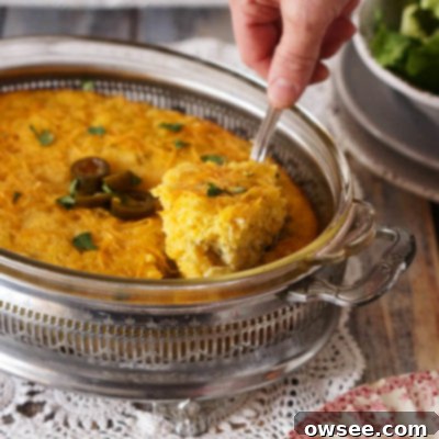 Savory Mexican Corn Pudding 6 A top-down view of a baking dish filled with golden-brown Mexican Spoon Bread, garnished with fresh cilantro and a few sliced jalapeños.
