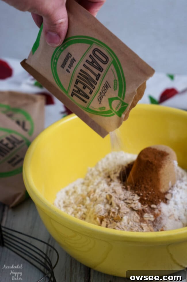 Effortless Oatmeal Scones 3 Instant oatmeal being poured into a bowl with other dry scone ingredients.