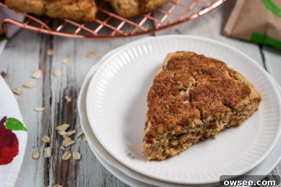 Effortless Oatmeal Scones 8 A freshly baked, golden brown instant oatmeal scone, showing its tender crumb, on a white plate ready to be enjoyed.