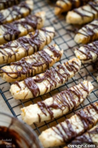 Irresistible Chocolate Almond Biscotti 2 A fresh batch of golden-brown Chocolate Almond Biscotti drying on a cooling rack, glistening with anticipation for their chocolate drizzle.