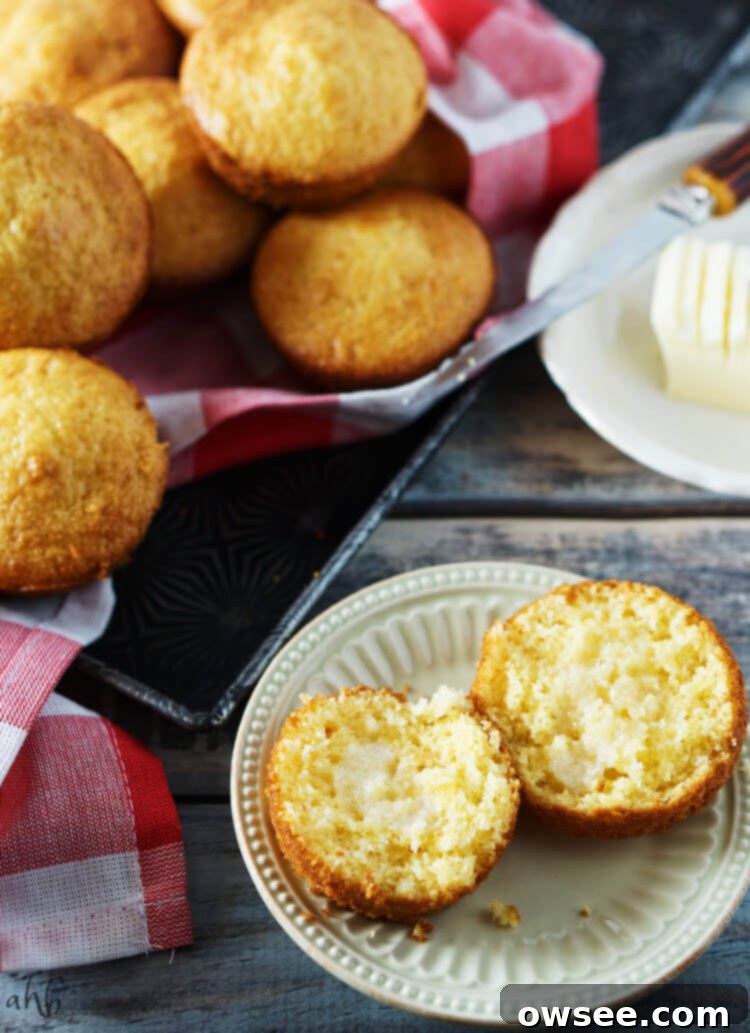 A cornbread muffin sliced with melted butter in the center.
