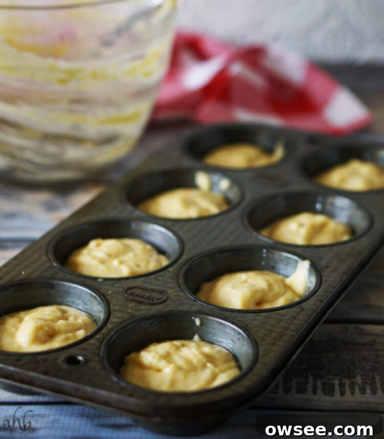 A muffin tin filled with cornbread batter, ready to pop into the oven.