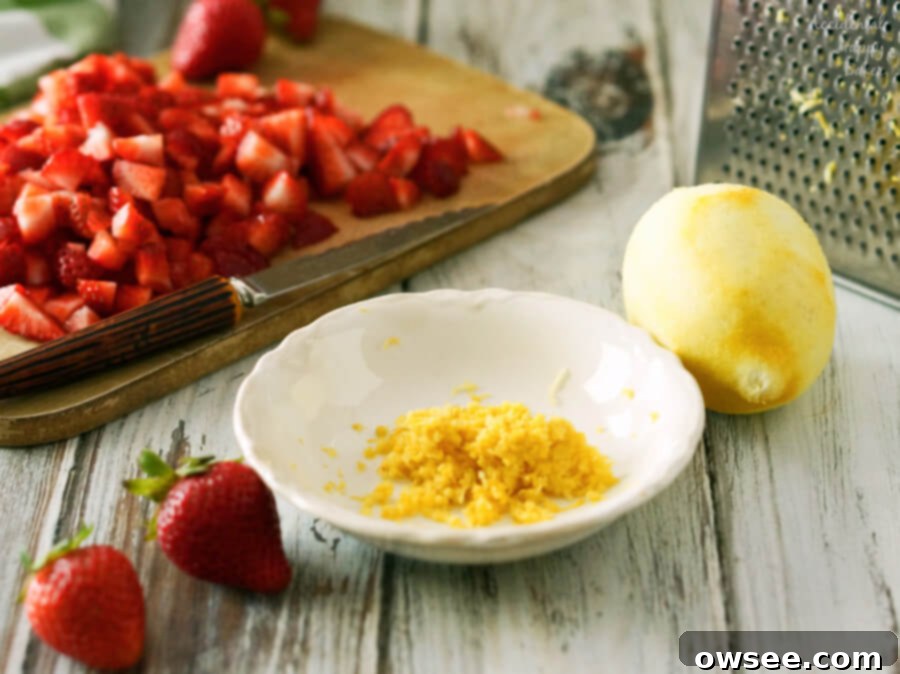 A bowl of fresh lemon zest and diced strawberries, ready for scone dough.