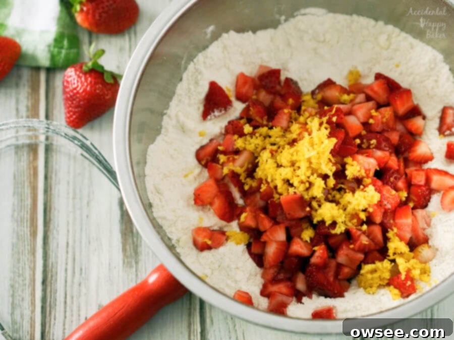 Chopped strawberries and lemon zest in a bowl, ready to be added to scone dough.