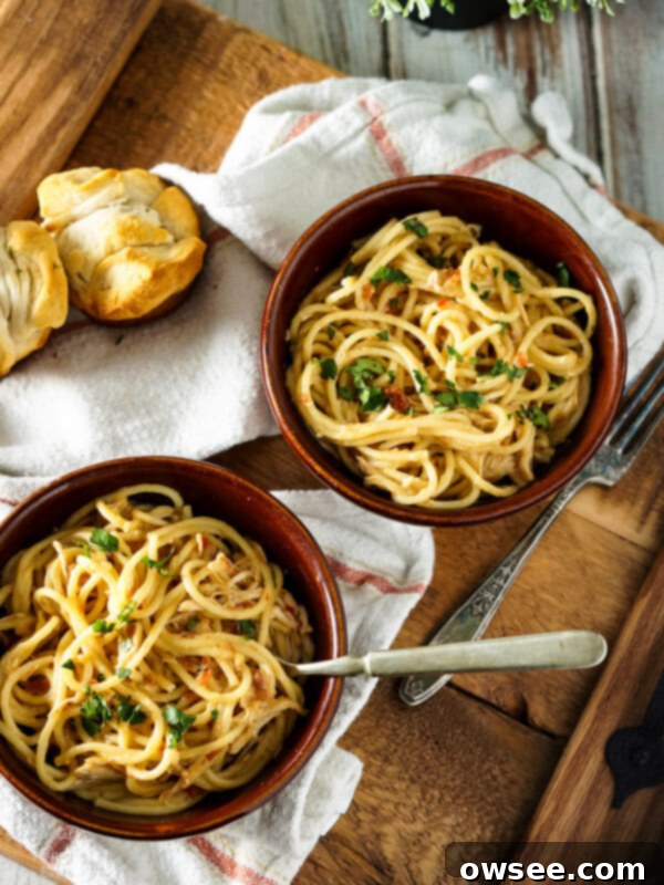 Crockpot Chicken Spaghetti with garlic rolls and salad, ready to be served.