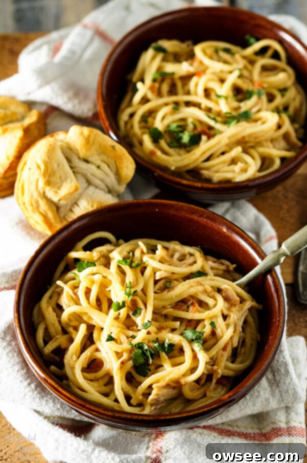 Creamy Crockpot Chicken Spaghetti ready to be served, garnished with fresh herbs.