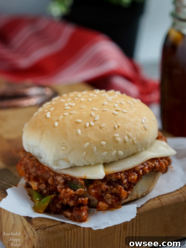 An assembled Italian Sloppy Joe with melted provolone cheese on a bun, ready to eat.