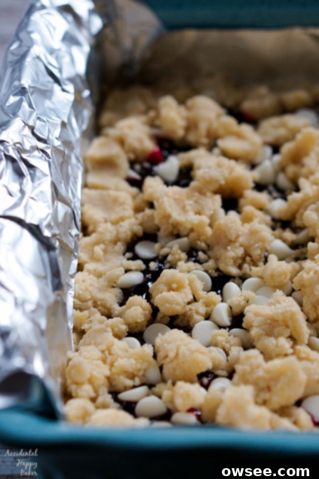 The remaining shortbread dough is crumbled over the raspberry jam and white chocolate chip filling.