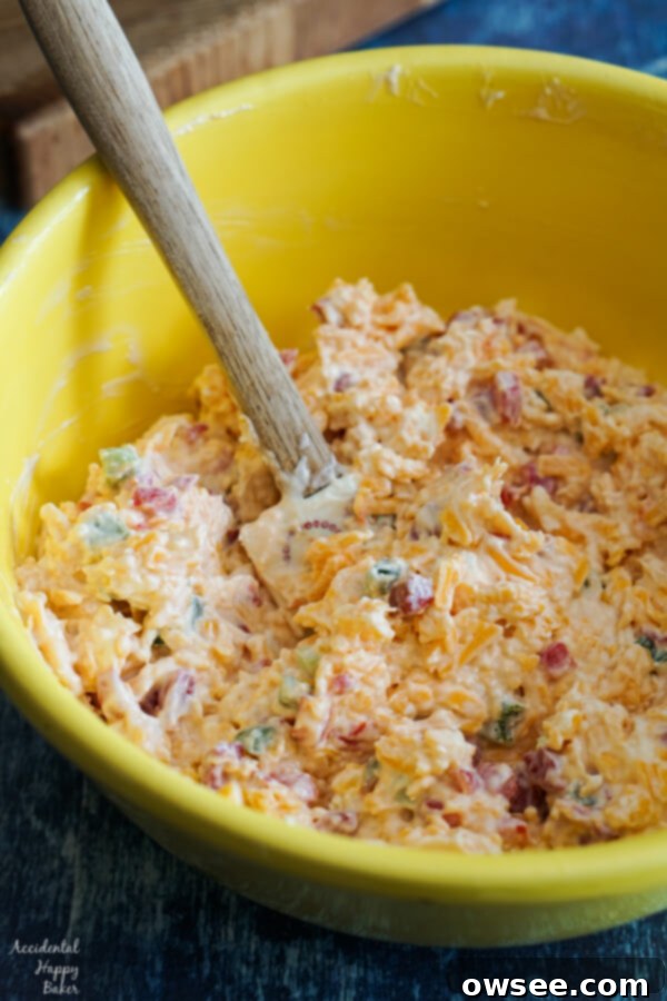 A bowl of Jalapeno Pimento Cheese being mixed, showing the creamy texture before serving.