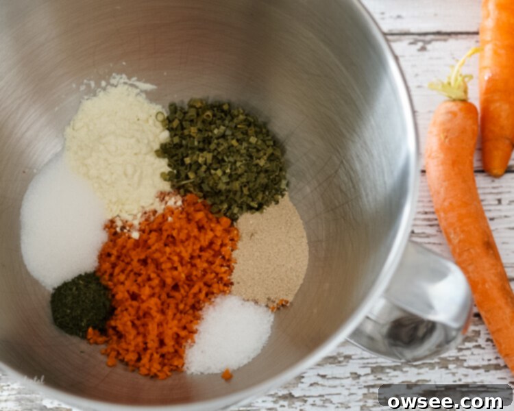 Bowl of shredded carrots, chives, dill weed, salt, sugar, yeast, and dried buttermilk ready for mixing.