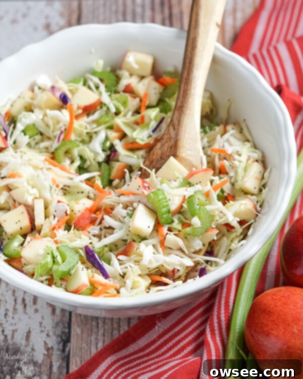 Vibrant Apple Cabbage Slaw with Luscious Poppy Seed Dressing 6 A large white serving bowl full of apple coleslaw.