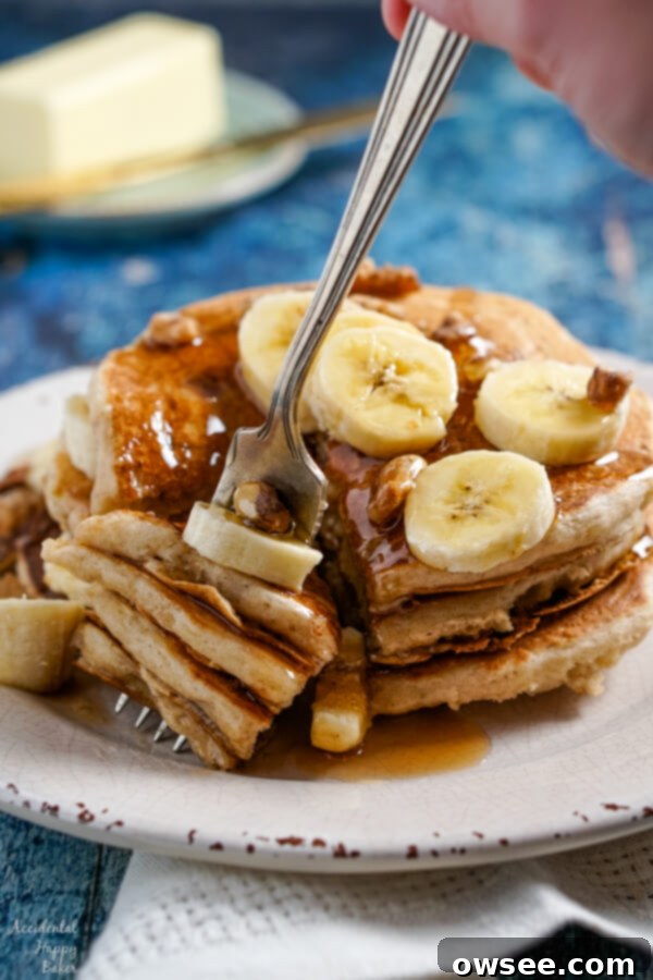 Fluffy Banana Bliss 6 Several layers of banana pancakes speared on the end of a fork.