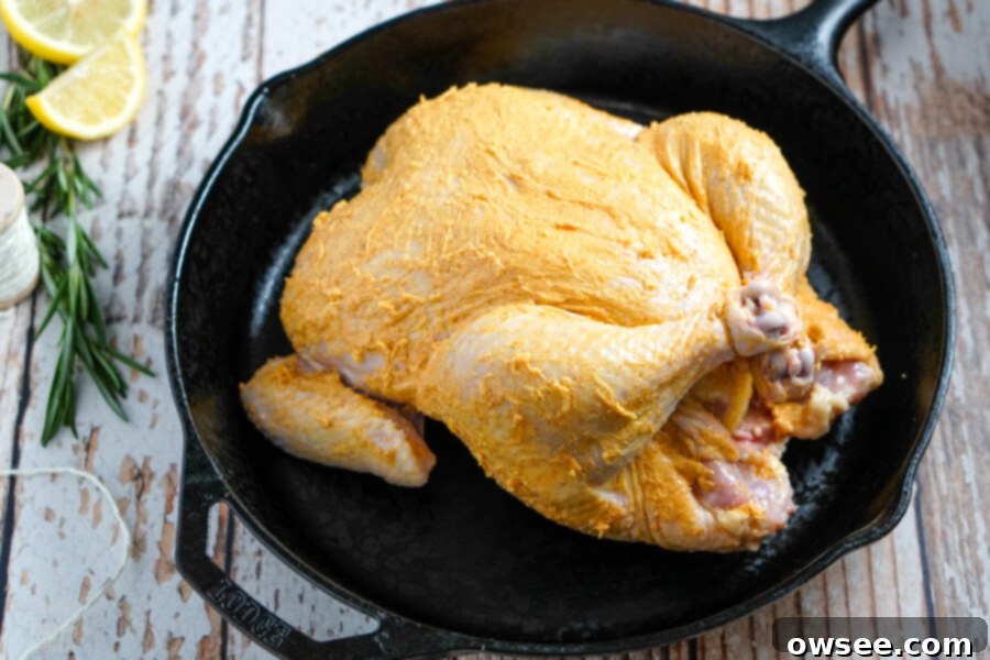Perfectly Roasted Chicken 8 Tying the legs of a raw chicken together with kitchen twine, a process called trussing.