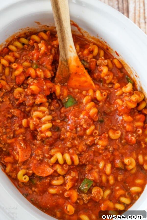 After the sauce has simmered, the pasta is added to the slow cooker. 