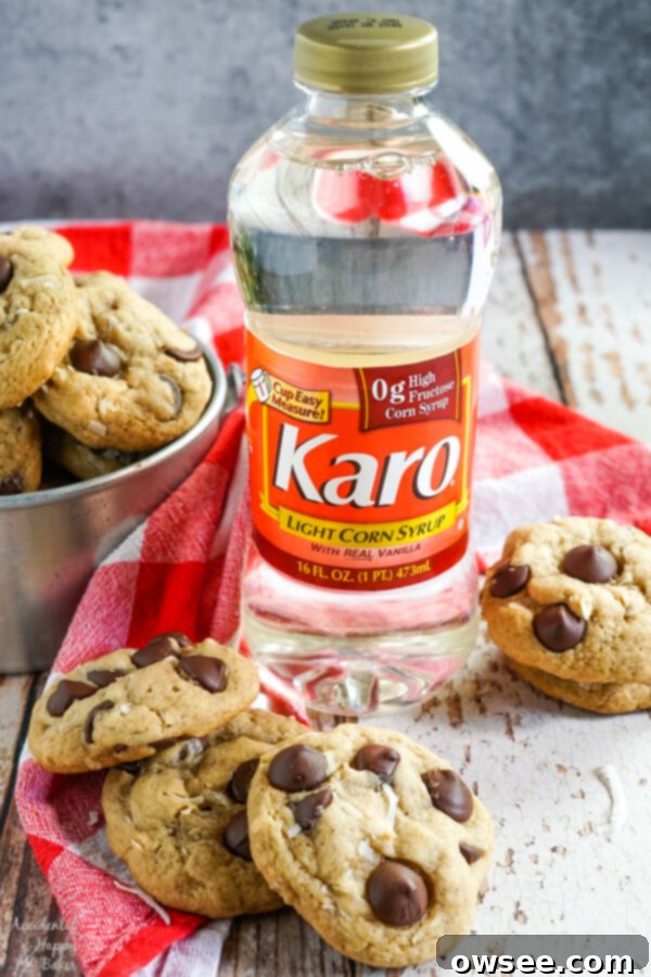 A stack of coconut chocolate chip cookies sits next to a bottle of Karo Corn Syrup