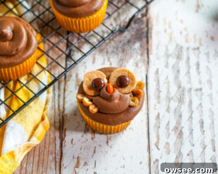 Adding two yellow Reese's Pieces candies to the bottom of the cupcake to serve as the owl's feet.