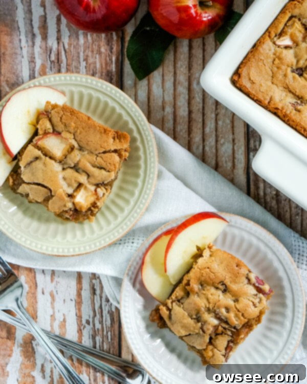 Irresistible Apple Cinnamon Bars 3 Two plates with slices of apple cinnamon bars next to forks, with a baking pan of bars in the background.