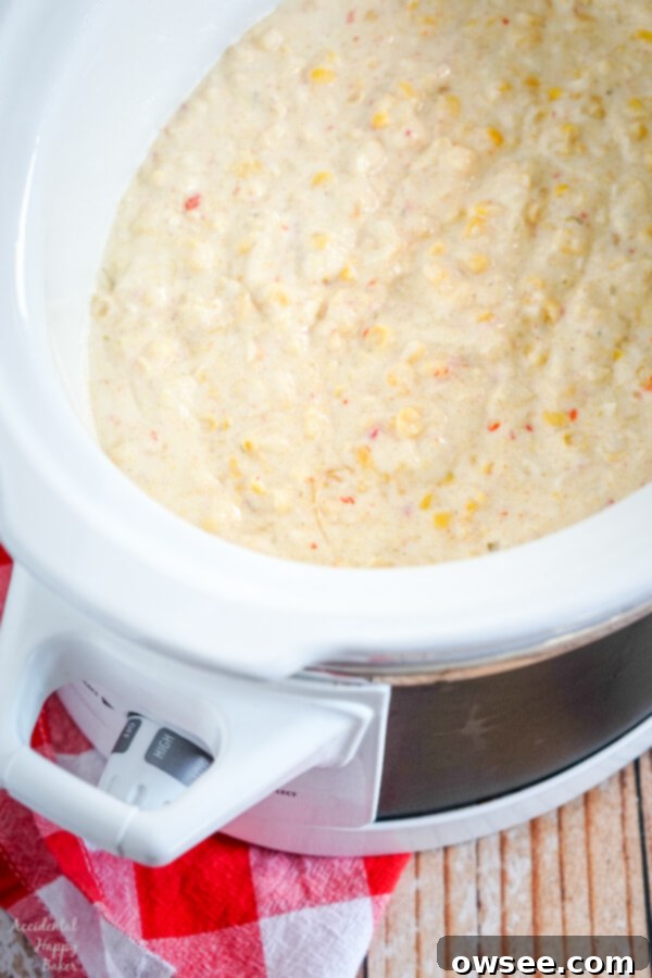 All the fresh ingredients for Crock Pot Corn Casserole laid out on a white surface, including canned corn, sour cream, cornbread mix, butter, and honey.