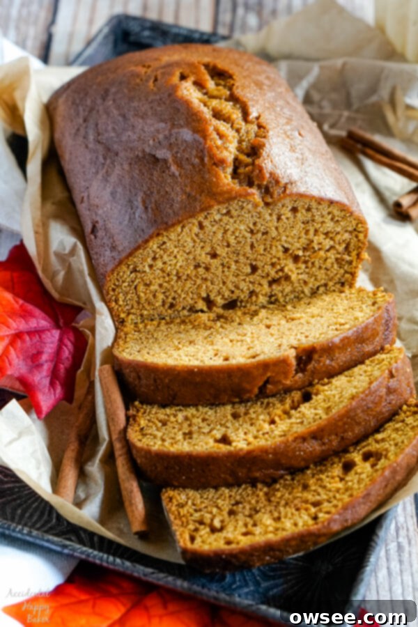 A loaf of Downeast Maine Pumpkin Bread, sliced and sitting on a baking tray.