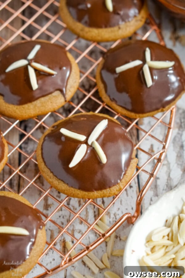 Freshly dipped and decorated German gingerbread cookies sit on a wire rack to dry. 