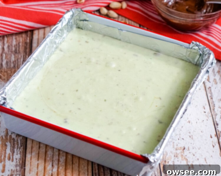 The hot pistachio fudge is poured into the foil-lined pan, ready for the chocolate swirl.