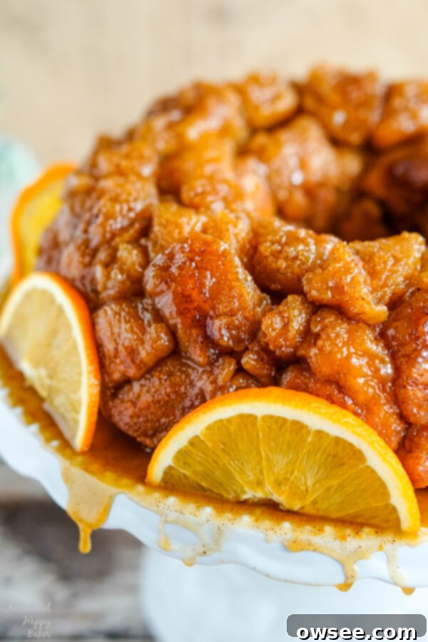 A platter of Orange Spiced Monkey Bread with syrup dripping off the platter. 