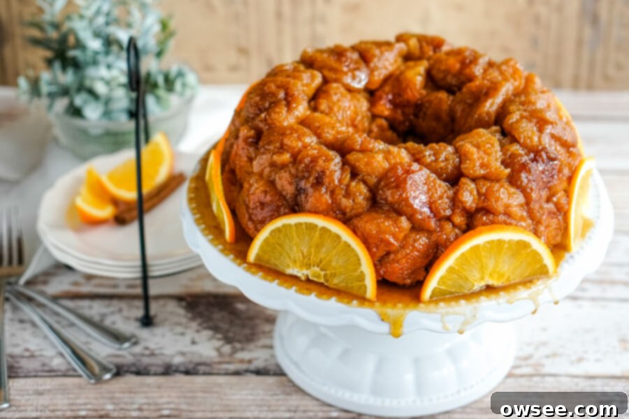 A plate of Orange Spiced Monkey bread beside a plate with sliced oranges. 