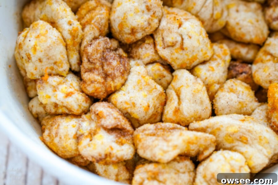 The biscuit pieces are rolled in the sugar mixture. 