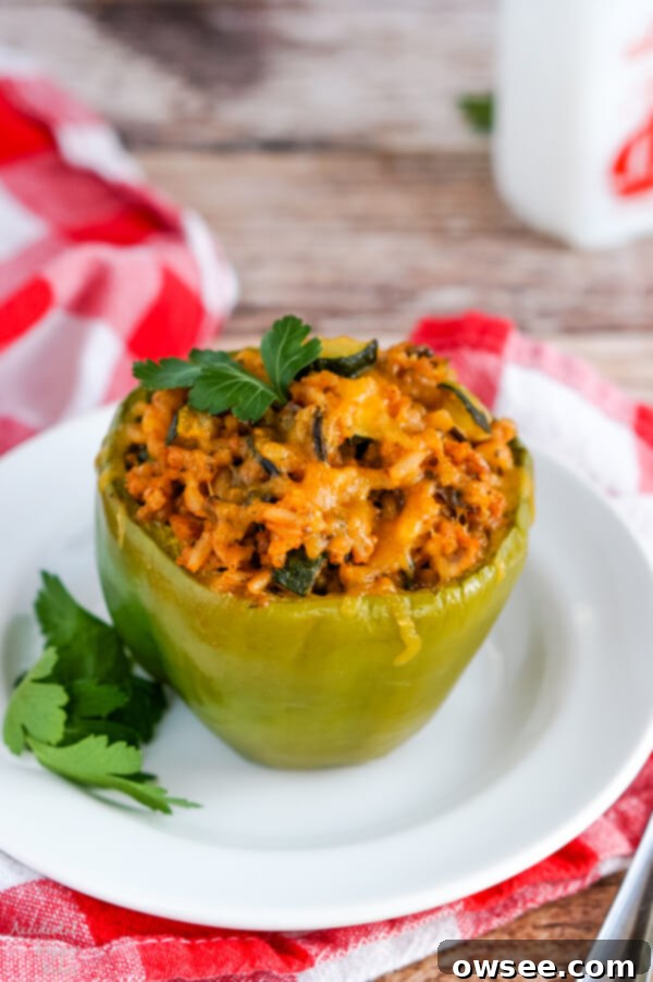 Beautifully baked wild rice stuffed bell peppers, a colorful and fresh main dish with sausage and vegetables, presented on a platter.