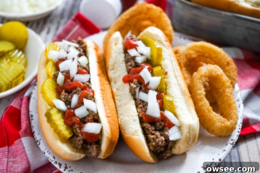 The Ultimate Midwestern Loose Meat Sandwich 6 Two Juicy Burgers topped with pickles, onions and ketchup on a plate with onion rings.