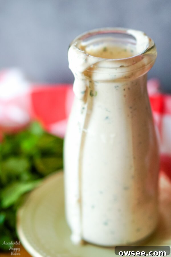 A bottle of homemade cilantro jalapeno ranch dressing, showcasing its vibrant green hue and creamy texture.