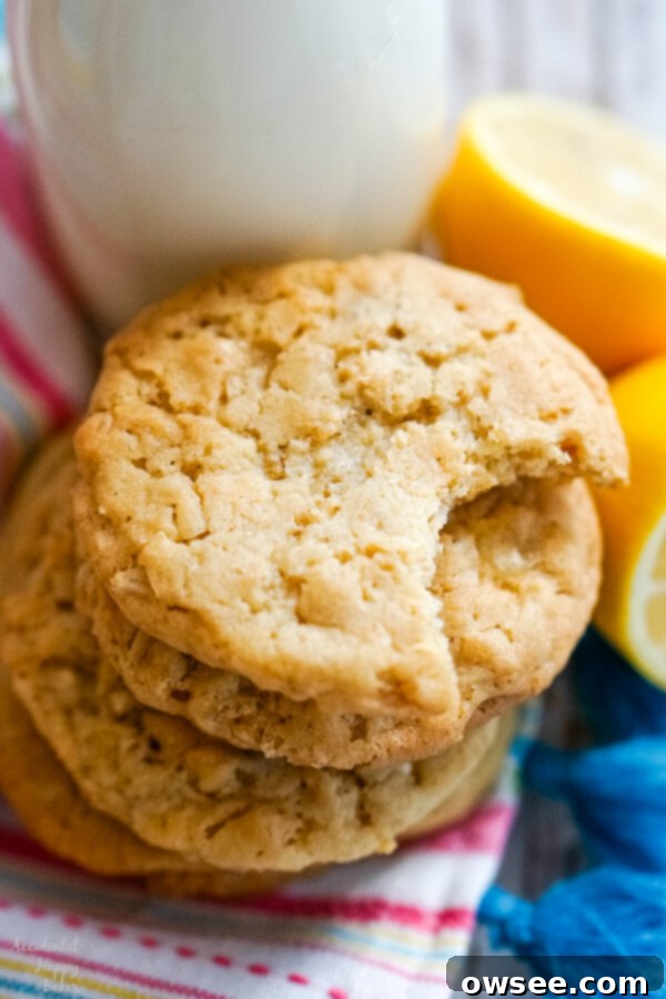 A charming stack of golden-brown lemon cowboy cookies, showcasing their inviting texture, placed neatly beside a refreshing bottle of milk.