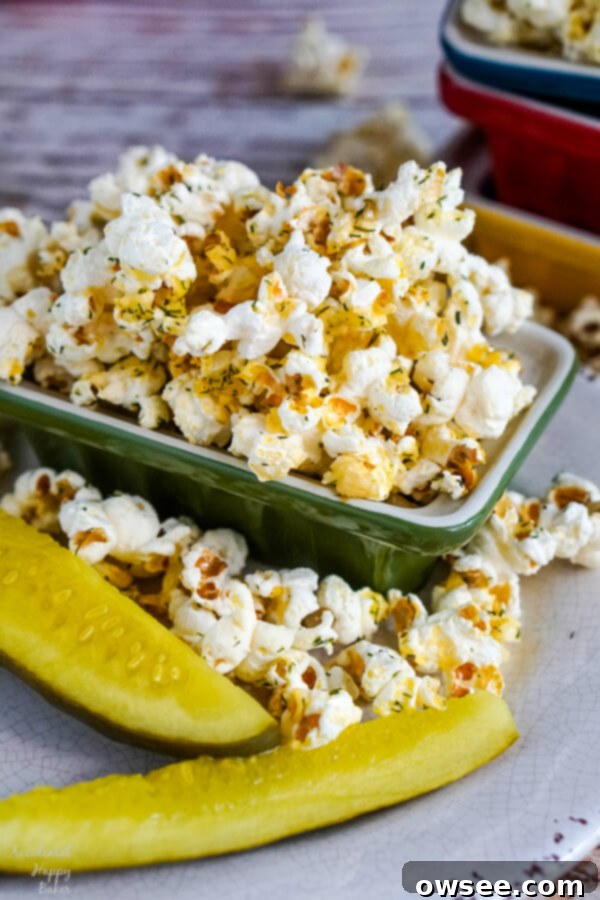 Dill Pickles and Popcorn, a perfect pairing A charming image of dill pickles on a plate beside a generous bowl of perfectly seasoned dill pickle popcorn.