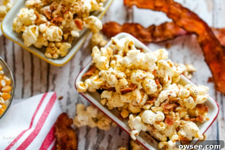 Two generous bowls filled with fluffy, golden popcorn sit side-by-side on a wooden surface, next to a vibrant red and white striped kitchen towel.