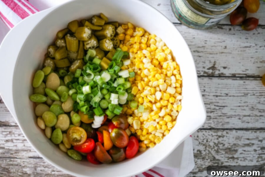 Vibrant Succotash Medley 4 Individual ingredients for succotash salad laid out: corn, lima beans, tomatoes, scallions, and pickled okra.