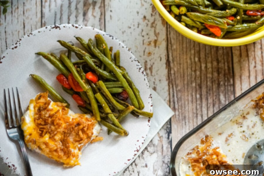 Comforting French Onion Smothered Pork Chops 3 A plated French Onion Smothered Pork Chop and roasted green beans, with serving dishes in the background.