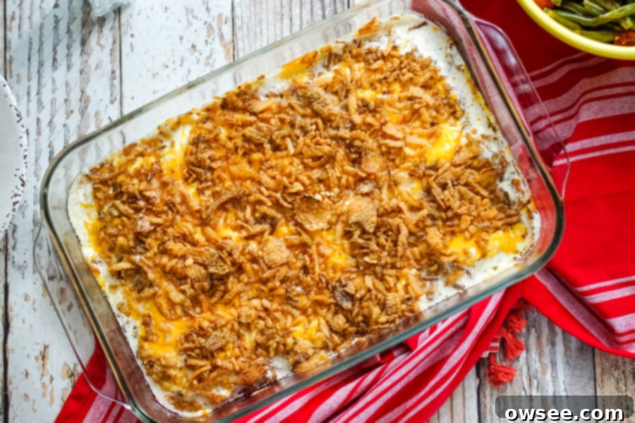 Comforting French Onion Smothered Pork Chops 6 A 9x13 baking dish of golden-brown French Onion Smothered Pork Chops, fresh out of the oven, resting on a red kitchen towel.