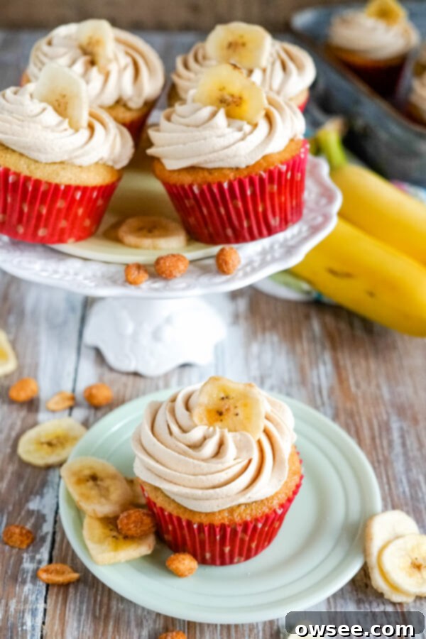 Banana Peanut Butter Bliss Cupcakes 2 A stand full of peanut butter banana cupcakes with a single cupcake in the front, beautifully frosted and ready to eat.