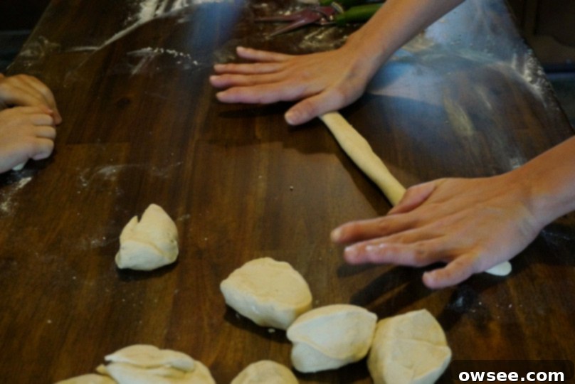 Child rolling pretzel dough into a rope