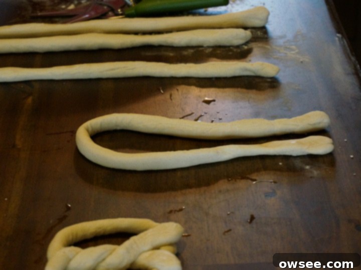 Child twisting pretzel dough into shape