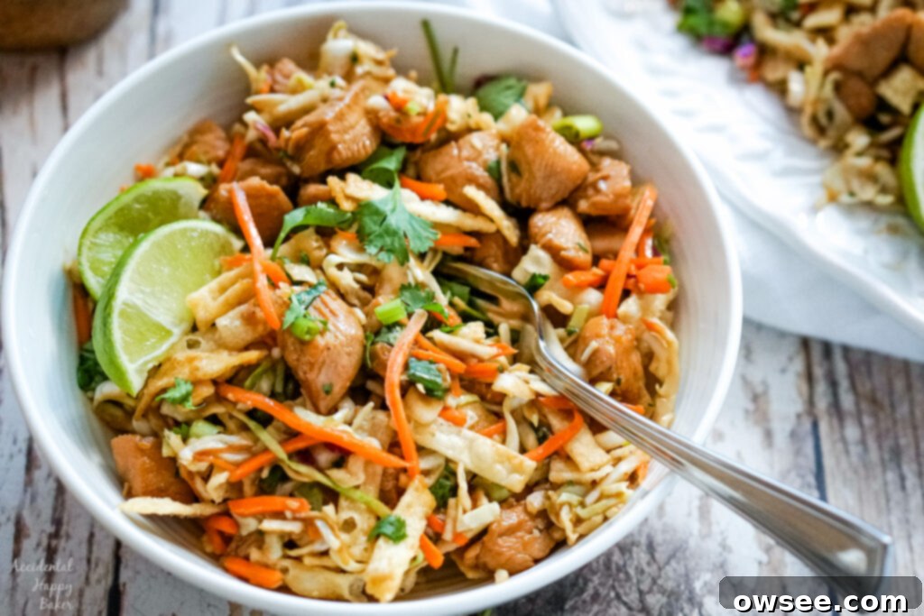 Crispy Wonton Chicken Taco Salad 7 A perfectly assembled bowl of Wonton Chicken Taco Salad, complete with a fork, ready to be enjoyed, with fresh lime wedges on the side for an extra zesty kick.