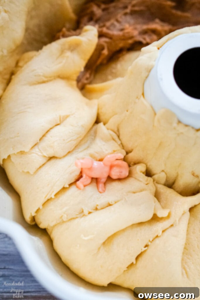 Effortless King Cake Celebration 7 The crescent rolls are folded over the filling and the baby trinket is tucked between the layers of the rolls.