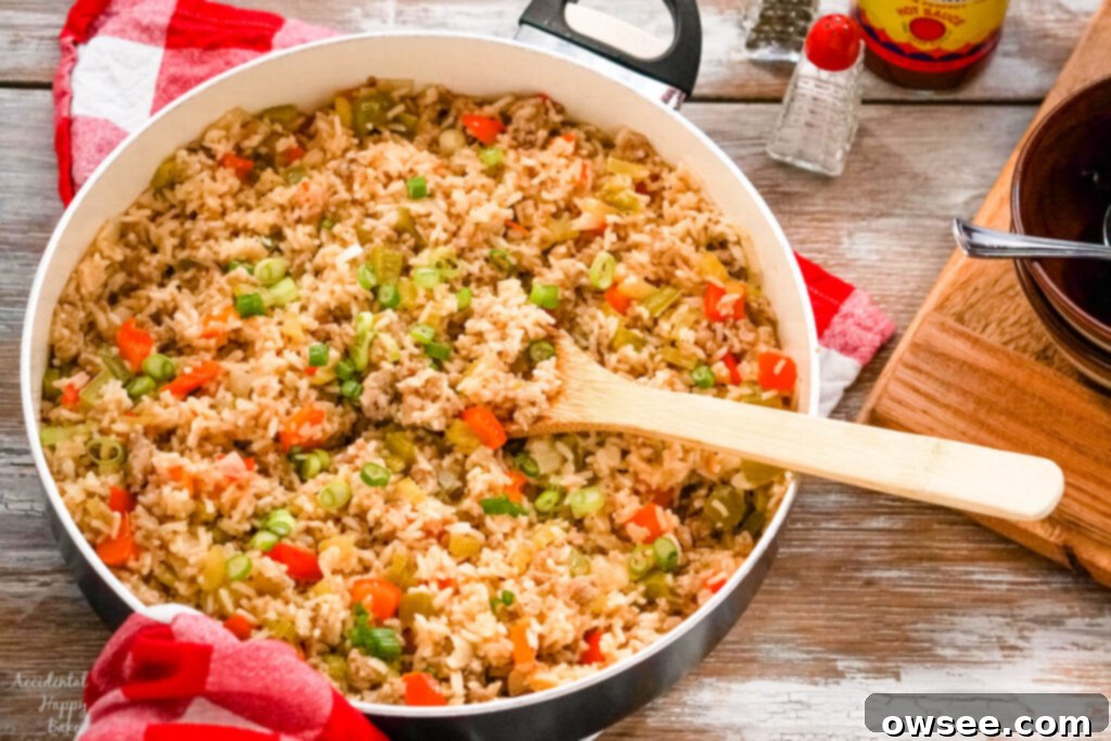 Savory Sausage Dirty Rice 7 A skillet of rice on top of a red checked towel next to salt and pepper shakers.