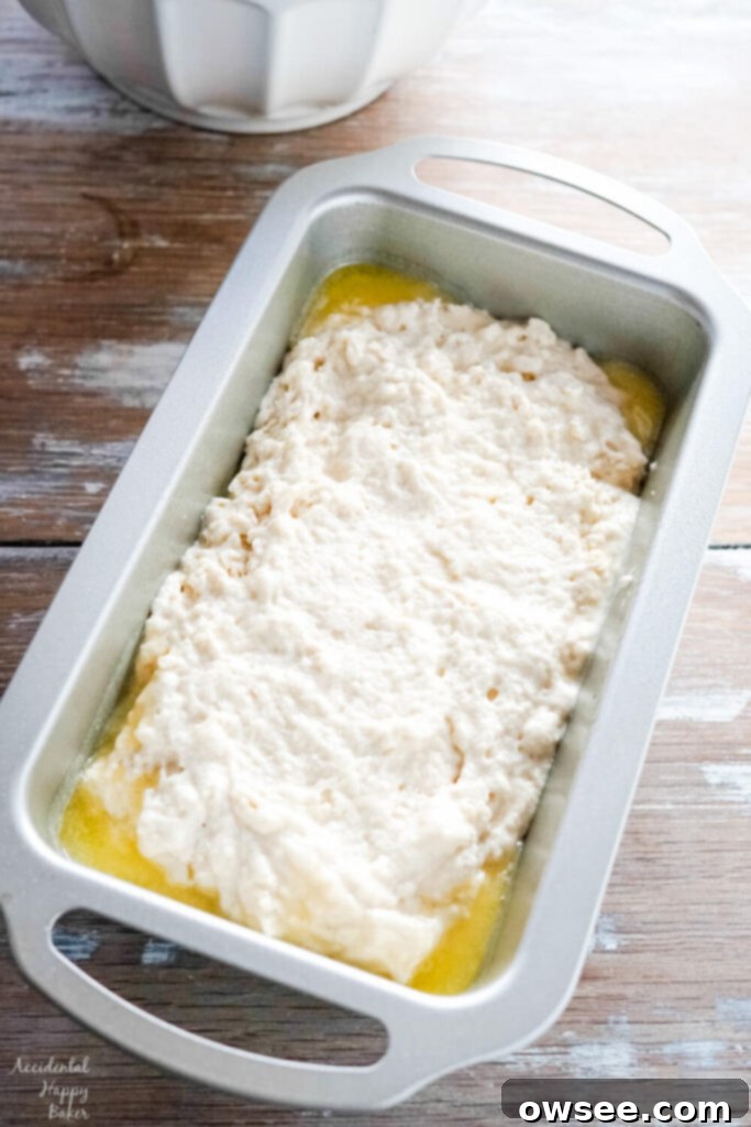 Golden Honey Beer Loaf 6 The beer bread batter is spread into a loaf pan that has been coated with melted butter.