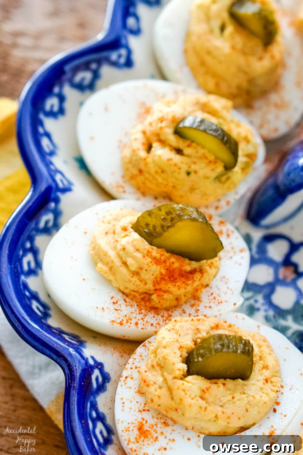 Spicy Deviled Eggs with a sprinkle of cayenne pepper and a slice of pickle on each egg.