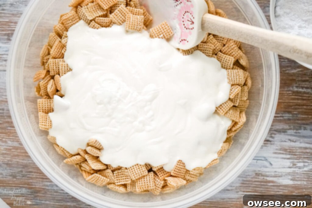 Ultimate Banana Cream Pie Muddy Buddies 5 A bowl of chex cereal with melted almond bark poured over it.